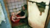 Женщина купает ребенка в общежитии