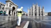 Работник в защитной одежде дезинфицирует площадь Пьяцца-дель-Дуомо в Милане, 31 марта 2020 года 