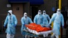 Медицинские работники доставляют тело умершего из медицинского центра Wyckoff Heights в Бруклинском районе Нью-Йорка, 2 апреля 2020 года