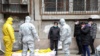 Работники похоронного агентства забирают тело покойного, умершего дома от коронавируса. Китай, Ухань, февраль 2020 года